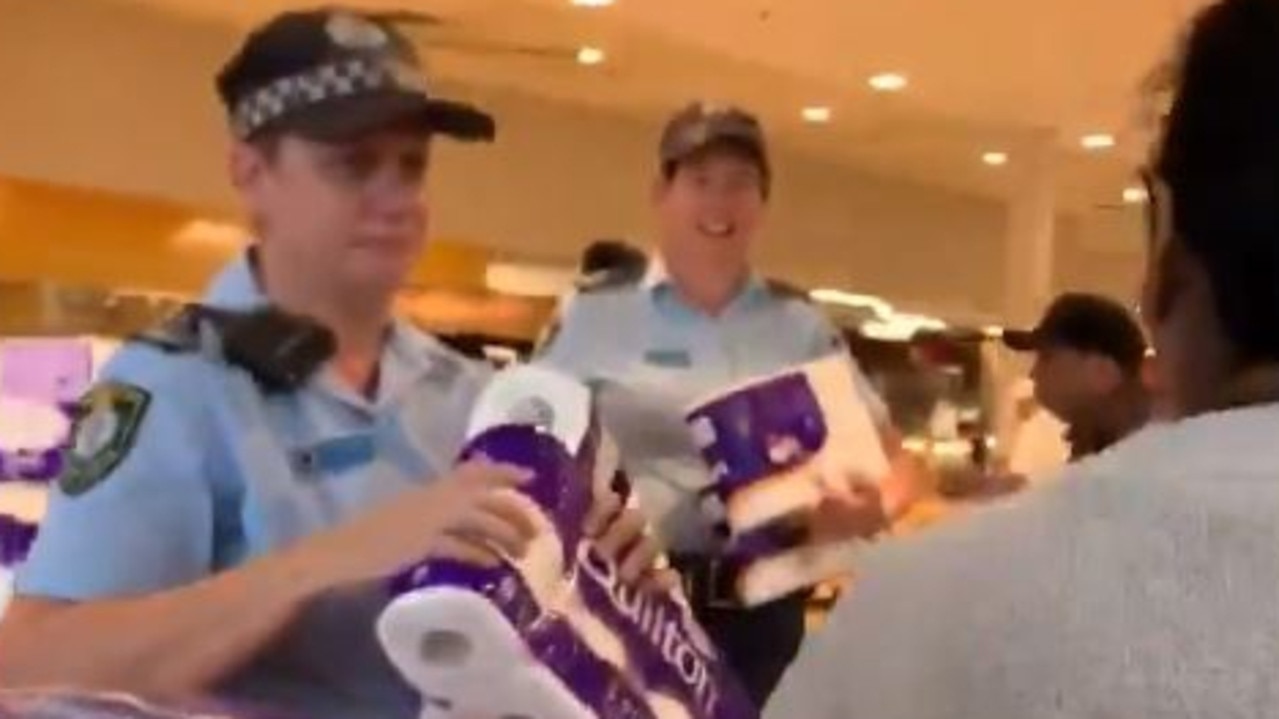 Police officers distributed toilet paper and paper towels at a Sydney supermarket on March 19, in a bid to calm coronavirus-related panic buying. Picture: Twitter/@rache23