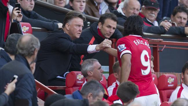 Manchester United's Radamel Falcao, center right, shakes hands with manager Louis van Gaal after being substituted during his team's 2-1 English Premier League soccer match win against Everton, at Old Trafford Stadium, Manchester, England, Sunday Oct. 5, 2014. (AP Photo/Jon Super)