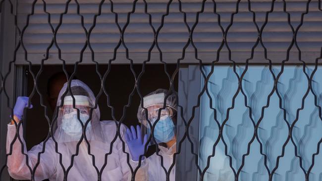 Members of the Military Emergencies Unit (UME) appear at a window during a general disinfection at a care facility in Madrid. Picture: Baldesca Samper/AFP