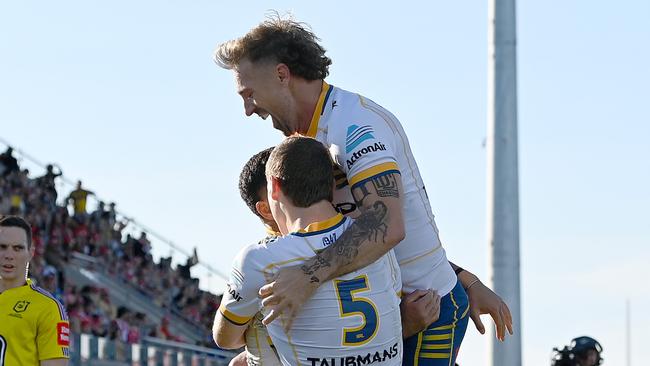 SUNSHINE COAST, AUSTRALIA - JUNE 24: Will Penisini of the Eels is congratulated by team mates Sean Russell and Bryce Cartwright of the Eels after scoring a try during the round 17 NRL match between the Dolphins and Parramatta Eels at Sunshine Coast Stadium on June 24, 2023 in Sunshine Coast, Australia. (Photo by Bradley Kanaris/Getty Images)