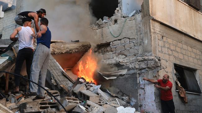 Palestinians climb on the rubble of a collapsed building looking for victims and survivors following a strike by the Israeli military on Khan Yunis. Picture: AFP