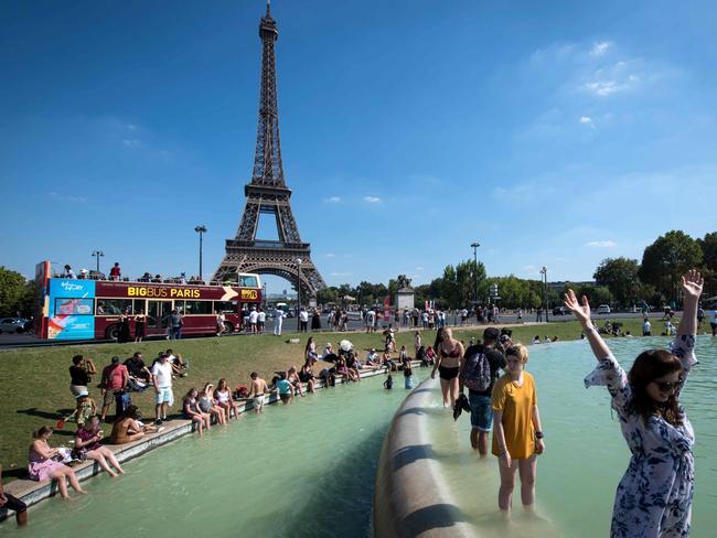 People cool themselves at the Trocadero Fountain in front of The Eiffel Tower in Paris. Picture: Gerard Julien