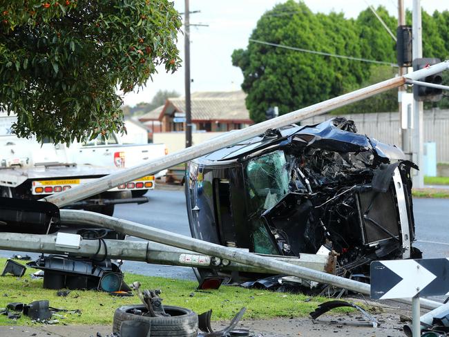 A black BMW SUV smashed into a light pole on the Bellarine Hwy. Picture: Alison Wynd