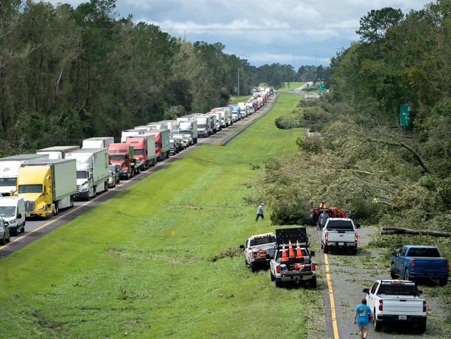 MADISON, FLORIDA - AUGUST 30: People work to clear I-10 of fallen trees after Hurricane Idalia crossed the state on August 30, 2023 near Madison, Florida. The storm made landfall at Keaton Beach, Florida as category 3 hurricane.   Sean Rayford/Getty Images/AFP (Photo by Sean Rayford / GETTY IMAGES NORTH AMERICA / Getty Images via AFP)