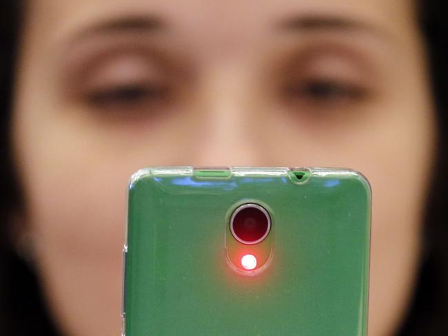 A woman uses a TaigaPhone, a brand new smartphone created by InfoWatch Group, during a presentation in Moscow on September 22, 2017. The phone, which is entirely green to represent the Russian northern forest after which it is named, has a five-inch touch screen, two SIM slots and two cameras. InfoWatch says the device can guarantee the confidentiality of all TaigaPhone users, track the location of each device and prevent information leackage. The company plans to sell TaigaPhone to Russian companies at a cost of between 12,000 and 15,000 rubles, almost five times cheaper than the cost of an iPhone in Russia. / AFP PHOTO / Maxim ZMEYEV