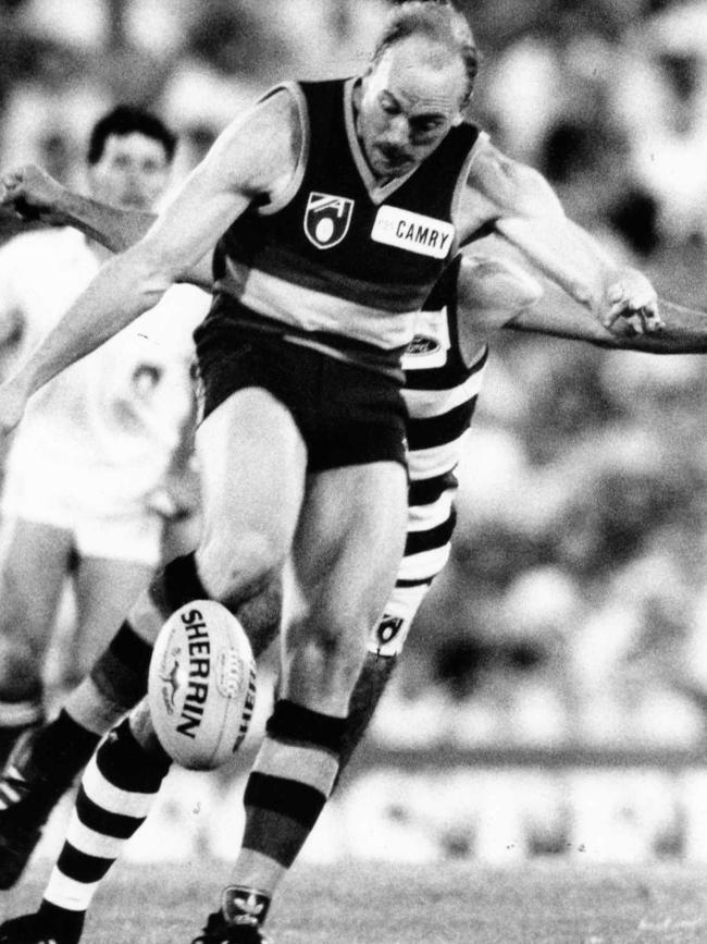 Bruce Lindsay kicks away from his Geelong opponent. 