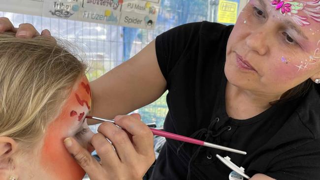 Venera paints a tiger on the face of Emma at the Fraser Coast Flavours Festival at Seafront Oval on September 1, 2023.