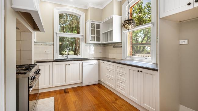 The kitchen has modern cooking appliances and a dishwasher.