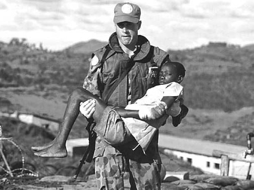 An Australian soldier carrying a young Rwandan boy injured during the Kibeho massacre in Rwanda, 1995.