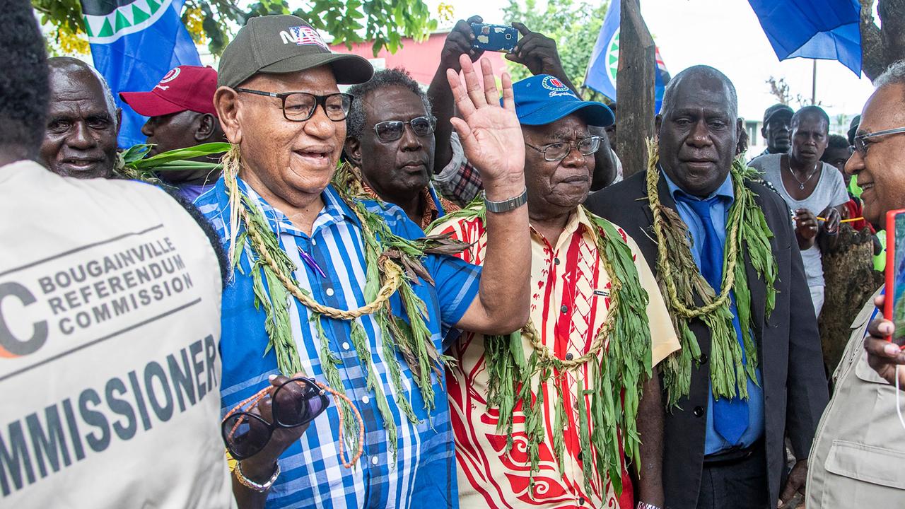 Bougainville regional president John Momis (L) waves as he arrives at a polling station to cast his ballot. Picture: NESS KERTON / AFP.