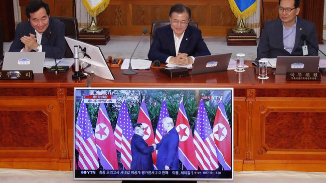 South Korean President Moon Jae-in, top centre, watches the summit between Donald Trump and Kim Jong-un on TV before the start of a cabinet meeting. Picture: AP