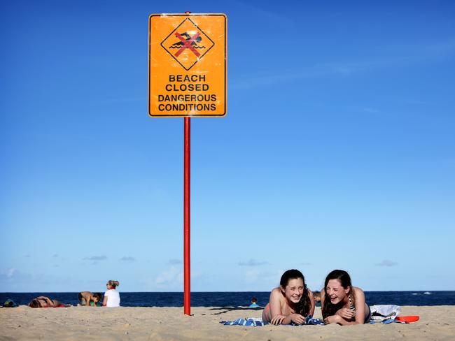 Coogee Beach closed off today although some people, including sisters Lili and Ali Lee had already travelled to the beach without knowing they couldn’t swim. Picture: Chris Pavlich