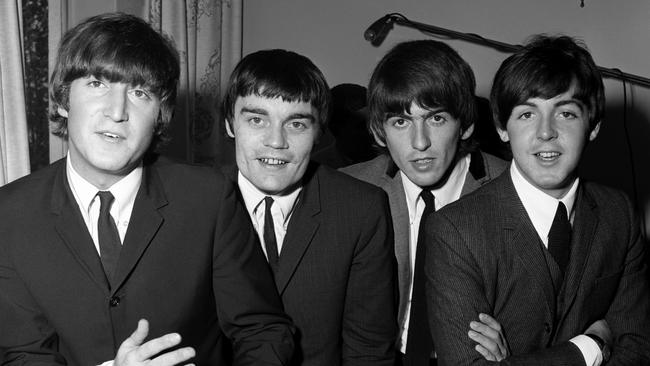 (L-R) English singer, songwriter and guitarist John Lennon (1940-1980), English musician, singer-songwriter and guitarist George Harrison (1943-2001) and English singer-songwriter and multi-instrumentalist Paul McCartney of the Beatles pose for a portrait with British drummer Jimmie Nicol, who was replacing Ringo Starr for two weeks while Ringo had tonsillitis during their world tour on June 12, 1964 at the Centennial Hall in Adelaide, Australia. (Photo by Jeff Hochberg/Getty Images)