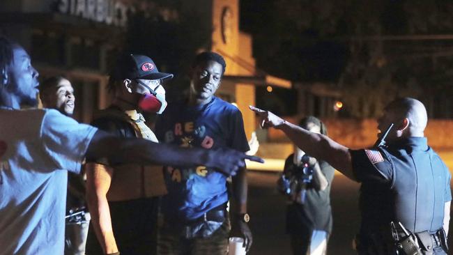 Protesters confront police during a protest in the death of George Floyd in Memphis as rioting spread from Minnesota to other American cities.