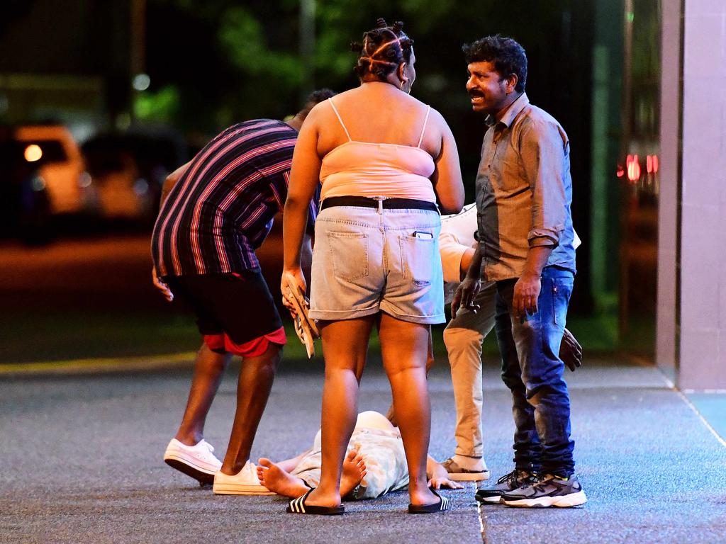 A man helps a New Year's Eve reveller as they make their way home in the early hours of New Year's day