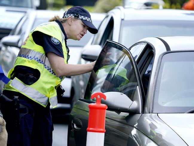 A police officer gestures to a driver at a checkpoint at Coolangatta on the Queensland - New South Wales border, Thursday, April 9, 2020. The Queensland Government  is introducing new border control measures effective Friday where Queensland residents crossing the border back into Queensland will also now need a permit.  (AAP Image/Dave Hunt) NO ARCHIVING