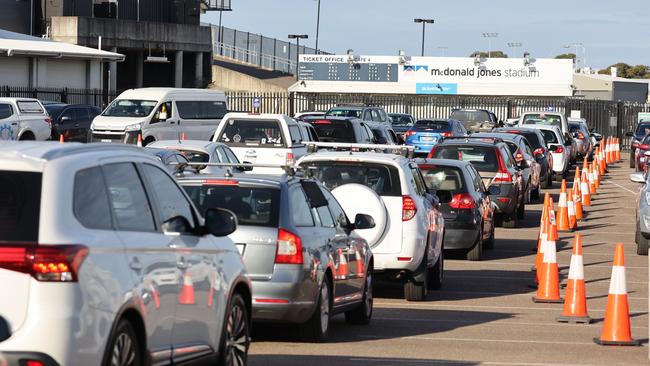 Long lines of cars at the McDonald Jones Stadium testing facility. Picture: David Swift.