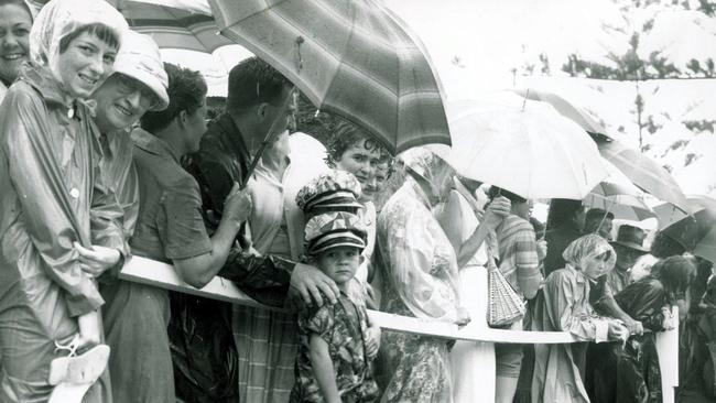 Gold Coast Crowds wait for Queen Elizabeth II in rain at Coolangatta Surf carnival.