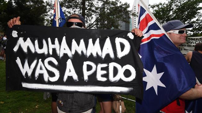 What news is this guy reading? A supporter of the far right anti-Islam group Reclaim Australia holds an extremely offensive sign in Brisbane on the weekend. Picture: AAP Image/Dan Peled