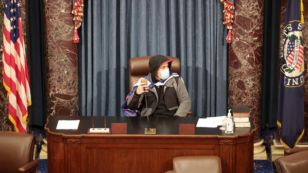 A rioter sits in the Senate Chamber after breaching the Capitol. Picture: Win McNamee/Getty/AFP
