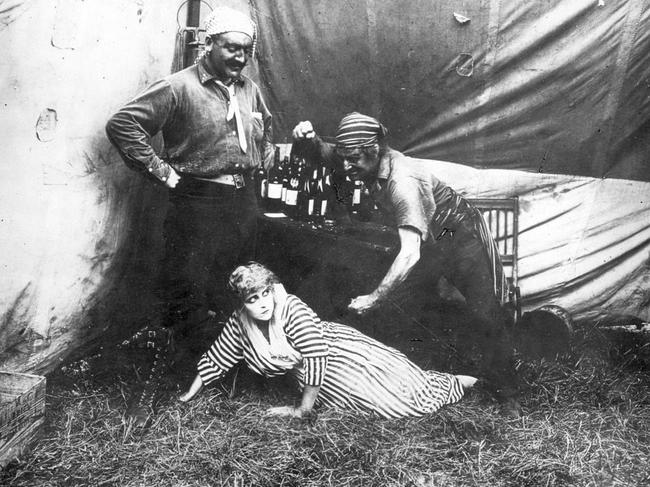 Actor Pearl White and two unidentified men in a scene from the 1914 film serial The Perils of Pauline. Out of copyright