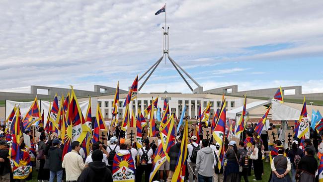 Members of the Australian Tibetan community hold flags and placards as they protest at a rally organised by the Alliance for Victims of the Chinese Communist Regime outside Parliament House in Canberra. Picture: David Gray/AFP