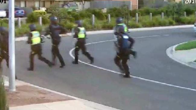 Riot police rush into the street.