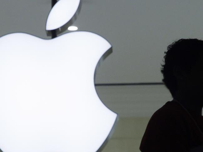 In a Wednesday, Dec. 7, 2011 file photo, a person stands near the Apple logo at the company's new store in Grand Central Terminal, in New York. If Apple had been added to the Dow in June 2009, the last time there were serious rumors that it would happen, the average would be about 2,500 points higher than it is today and well above its all-time high.(AP Photo/Mark Lennihan, File)