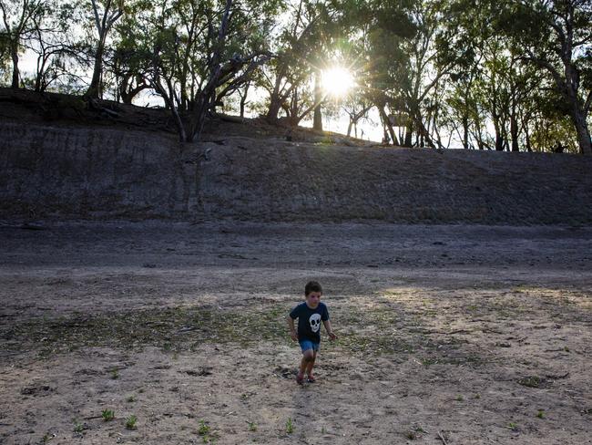 Casey Cohen runs along the dry bed of the Darling River waiting for the arrival of water. Picture: Jenny Evans