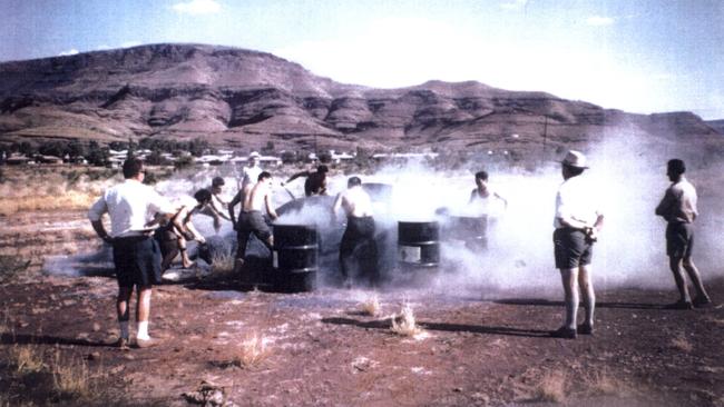 Raw blue asbestos tailings are shovelled into drums at a competition at Wittenoom, in the Pilbara, WA, in 1962.