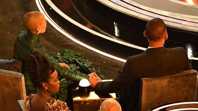 The Smiths hold hands during the Academy Awards ceremony.