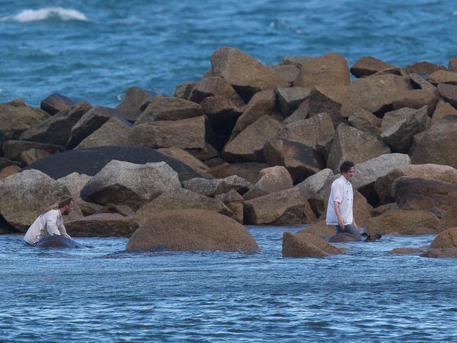 Jeff Della-Mina and Dan Marshall bring the stricken animal ashore from the freezing waters. Picture: Stephen Muller