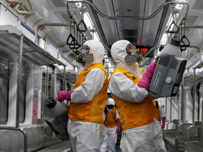 Workers disinfect a subway car depot in Seoul. Picture: Reuters
