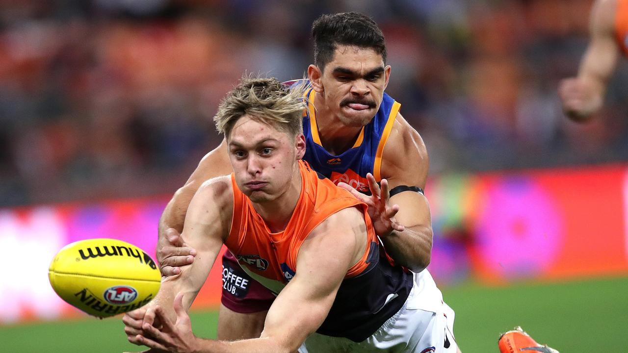 Jackson Hately handballs under pressure from Charlie Cameron.