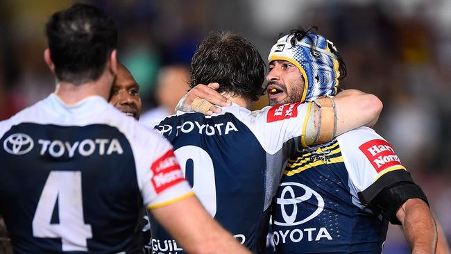 TOWNSVILLE, AUSTRALIA - SEPTEMBER 01: Johnathan Thurston of the Cowboys celebrates after kicking the winning field goal with Rory Kostjasyn and Kane Linnett of the Cowboys during the round 25 NRL match between the North Queensland Cowboys and the Cronulla Sharks at 1300SMILES Stadium on September 1, 2014 in Townsville, Australia. (Photo by Ian Hitchcock/Getty Images)