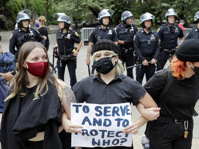 Protesters link arms in front of police officers in New York. Picture: AP