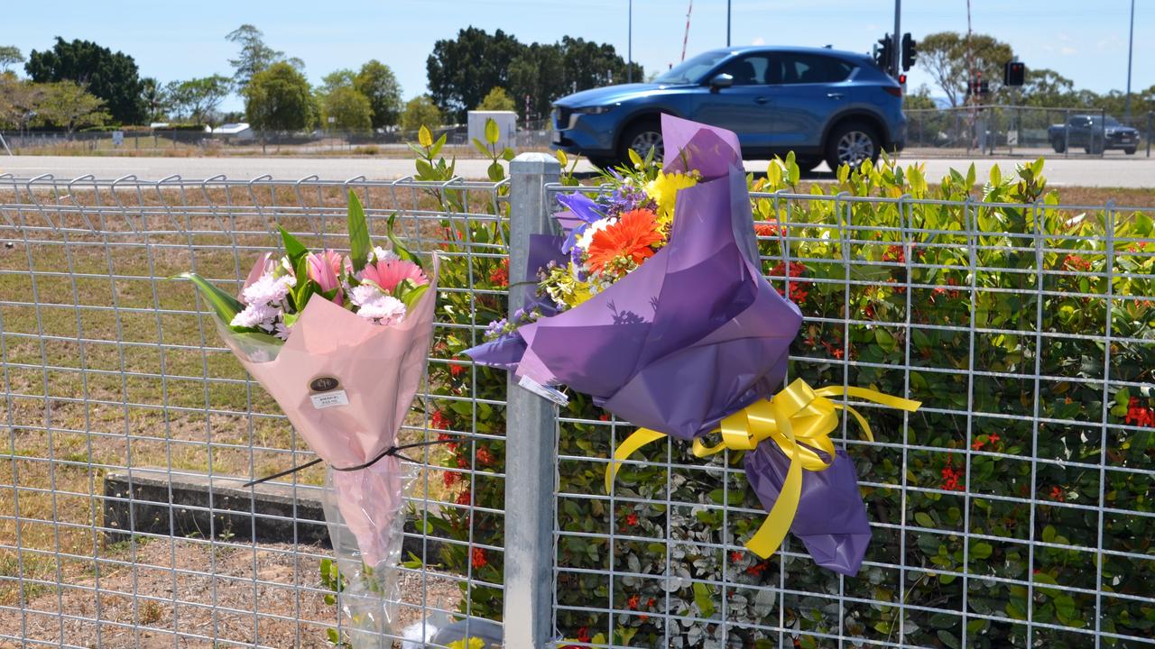 Heartfelt tributes, including bright pink flowers and a small stuffed toy, now mark the spot of a tragic crash that took the life of a 15-year-old girl in Townsville at an intersection off the Bruce Highway and Deeragun Rd at Deeragun. Photo: Jami Roberts