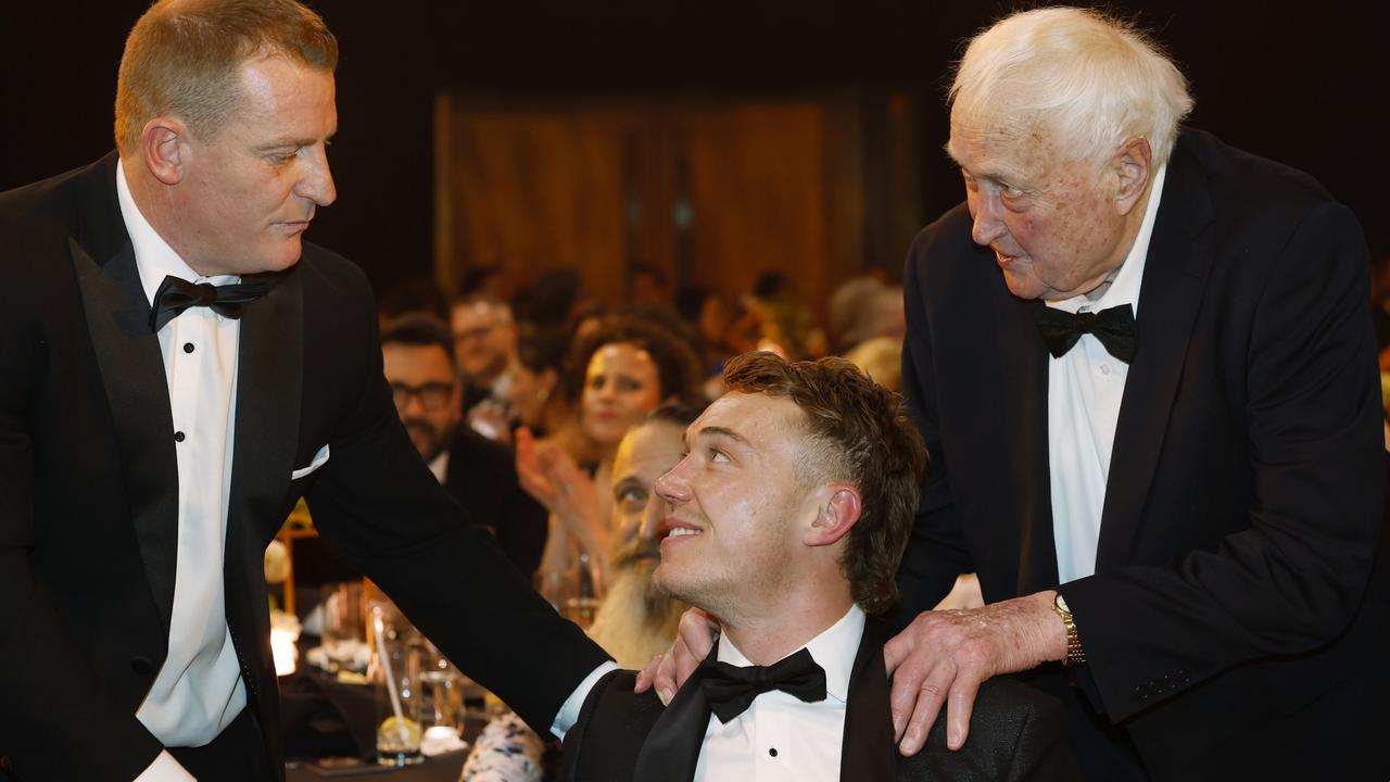 Patrick Cripps is congratulated by coach Michael Voss (left) and Carlton legend John Nicholls (right) after claiming his second medal on Monday night. Picture: Michael Klein