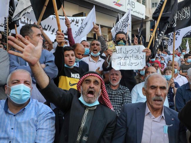 Palestinian supporters of the Islamist Hizb al-Tahrir (Liberation) party lift flags and placards during a rally to protest comments by French President Emmanuel Macron over Prophet Mohammed cartoons,in the West Bank city of Hebron, on October 31, 2020. (Photo by HAZEM BADER / AFP)