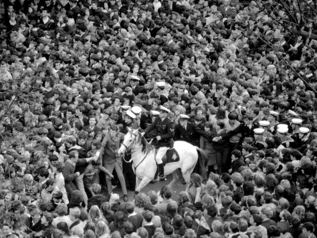 June 14, 1964: Mounted policeman face a hopeless task trying to control 10,000 people who flooded Exhibition Street to catch a glimpse of The Beatles at the Southern Cross Hotel. Picture: Herald Sun Image Library.