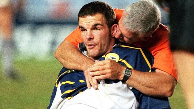 Ian Roberts receives treatment from a trainer after suffering concussion in high tackle.