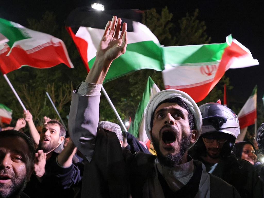 Des manifestants brandissent le drapeau iranien et des drapeaux palestiniens devant l’ambassade britannique à Téhéran. Photo : AFP