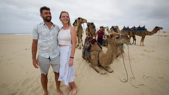 Paul Popescu, 29, and girlfriend Carly Faghy, 26, prepare to take a camel ride at Birubi Beach in Port Stephens now that regional NSW is re-opened for business. Picture: Liam Driver