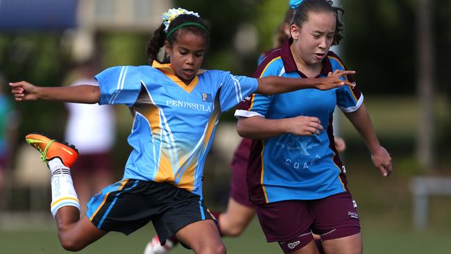 Mary Fowler (left) of Peninsula scores while being challenged by Chloe Shute of South Coast in the State School Soccer Championship held in Cairns.