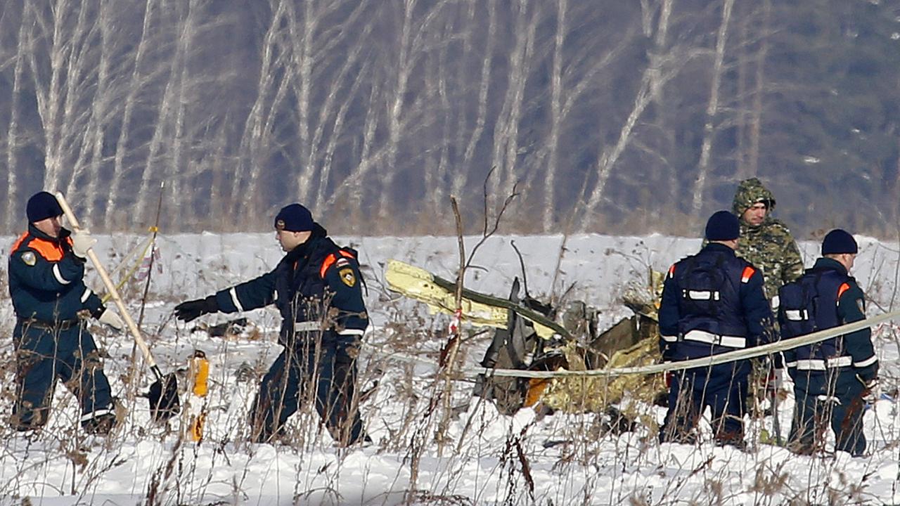 Emergency workers at the scene of the February 11 crash. Picture: AP/Alexander Zemlianichenko