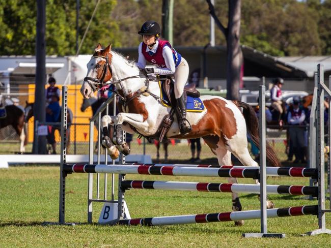 Calli Robertson clears the oxer at the PQC State Showjumping Championships 2023.