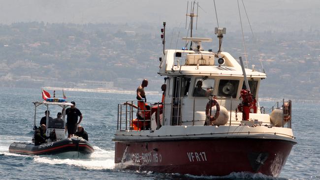 Divers of the Vigili del Fuoco, the Italian Corps of Firefighters with the body of the last missing person at the back of the boat. Picture: AFP