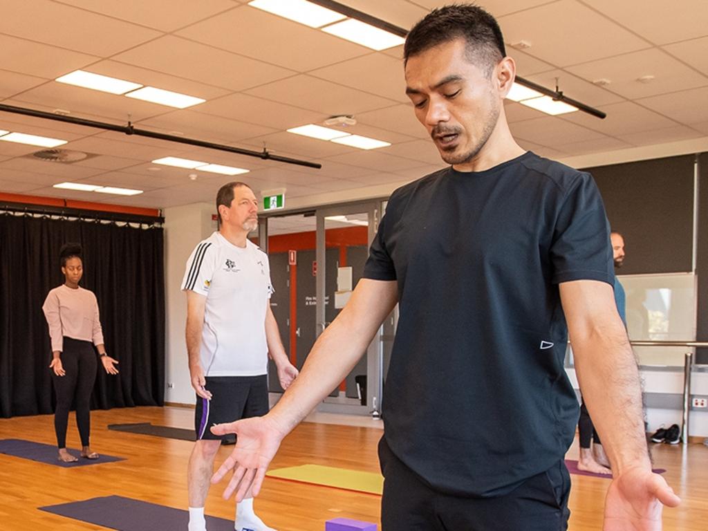 YOGA BARRIERS: University of Southern Queensland PhD student Jonathan Cagas (right) is leading research into what deters men from taking more yoga classes.