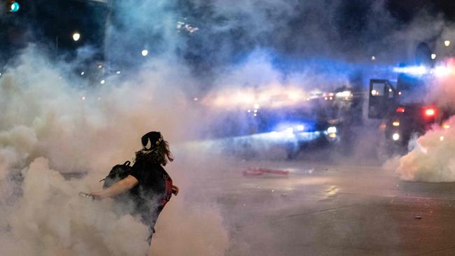 A protester hurls a teargas canister back at police in Detroit. Picture: AFP