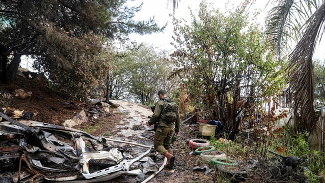 A soldier walks near a car destroyed in a strike by Lebanon's Hezbollah movement in Kibbutz Manara in northern Israel near the Lebanon border. (Photo by jalaa marey / AFP)